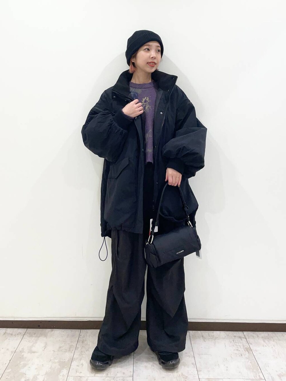 ブラック系のショルダーバッグ、パープル系のニット/セーター、ブラック系のカーゴパンツを着用したレディースの冬コーディネートの2枚目の写真