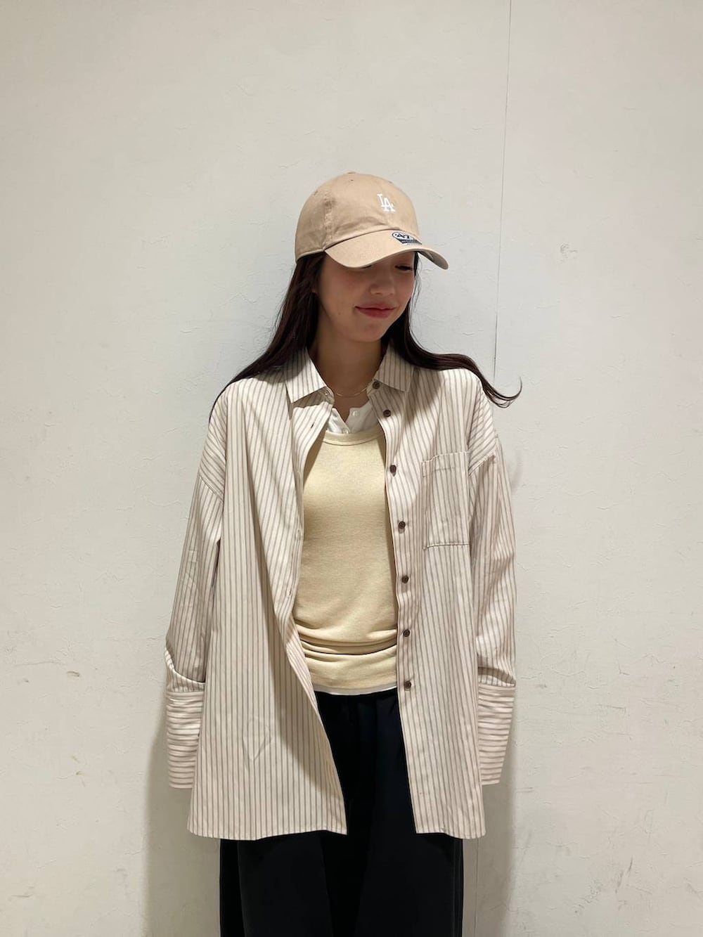 イエロー系のタンクトップ、ホワイト系のTシャツ/カットソー、ホワイト系のトートバッグを着用したレディースの春コーディネートの6枚目の写真