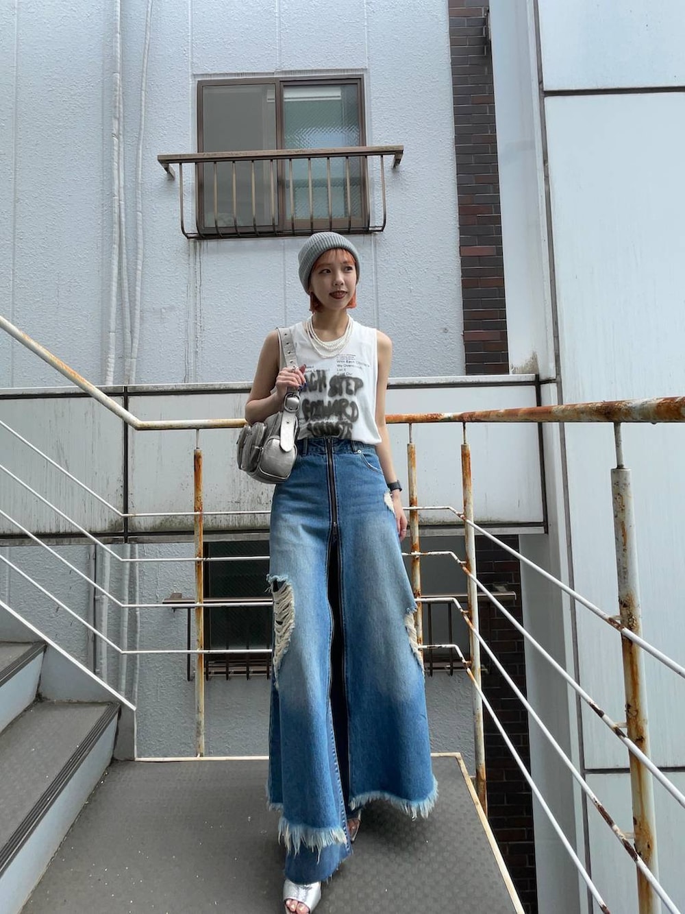 シルバー系のサンダル、ブルー系のスカート、シルバー系のショルダーバッグを着用したレディースの夏コーディネートの4枚目の写真