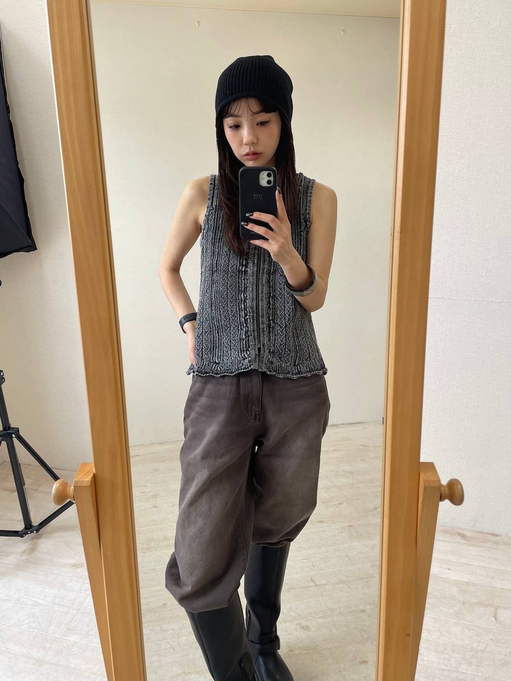 ブラウン系のデニムパンツ、ブラック系のベスト、ブラック系のブーツを着用したレディースの夏コーディネートの4枚目の写真