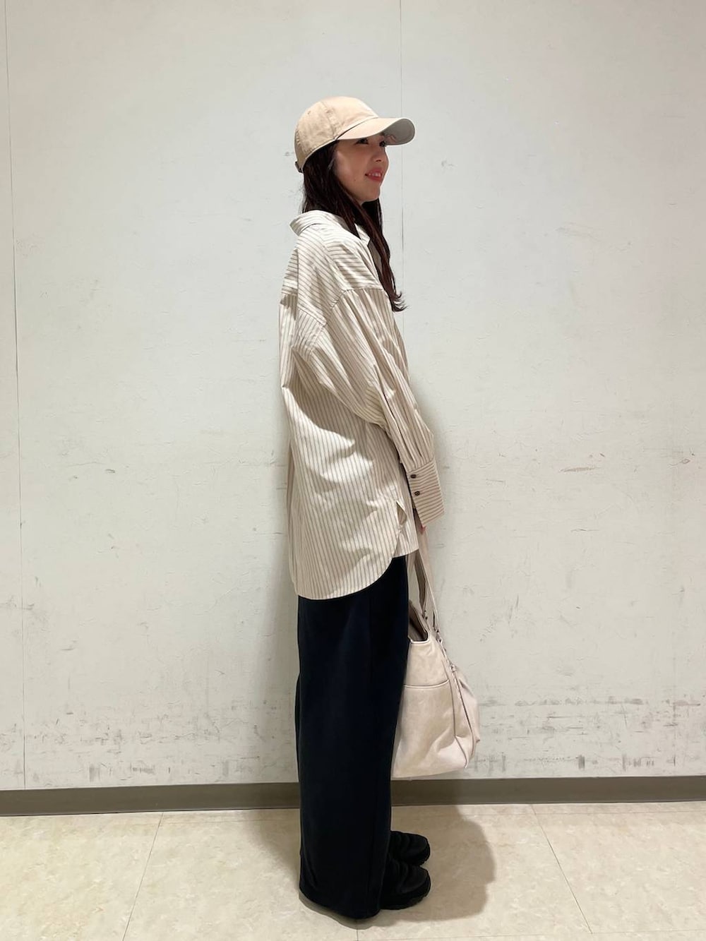 イエロー系のタンクトップ、ホワイト系のTシャツ/カットソー、ホワイト系のトートバッグを着用したレディースの春コーディネートの2枚目の写真