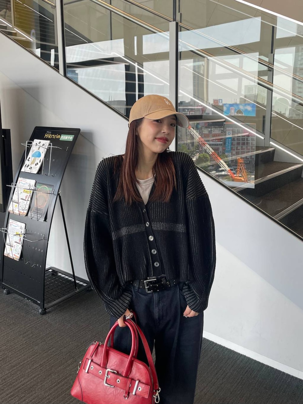 ベージュ系のタンクトップ、ブラック系のブーツ、ブラック系のデニムパンツを着用したレディースの秋コーディネートの2枚目の写真