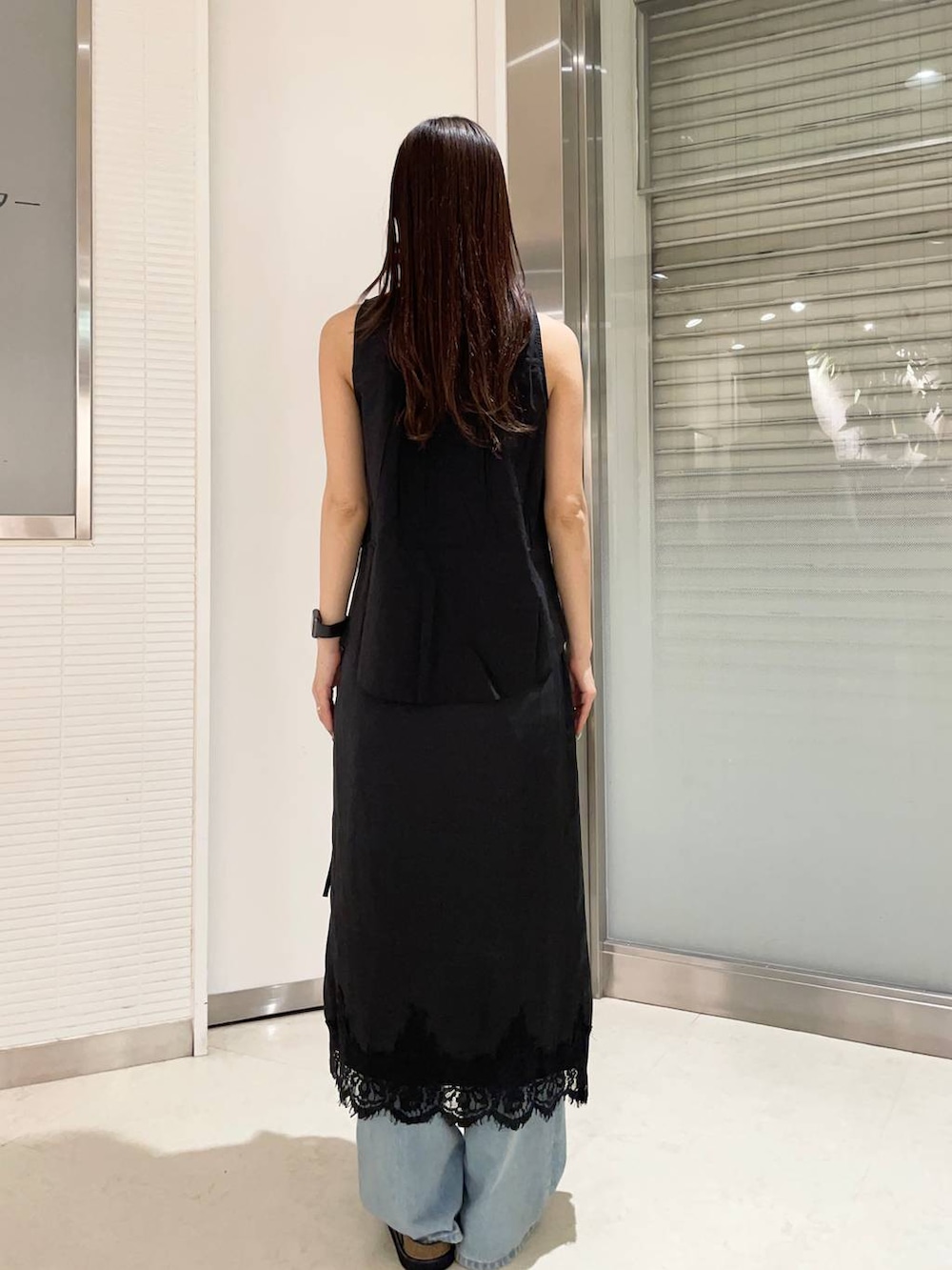 ブラック系のローファー、ブルー系のデニムパンツ、ブラック系のシャツ/ブラウスを着用したレディースの夏コーディネートの2枚目の写真