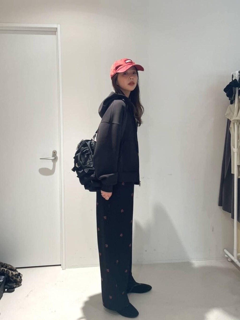 ブラック系のパンプス、ブラック系のボストンバッグ、ブラック系のパーカーを着用したレディースの冬コーディネートの2枚目の写真