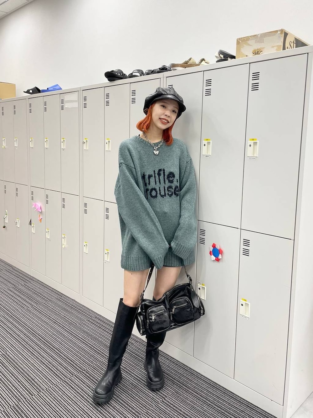 レッド系のショルダーバッグ、グレー系のデニムパンツ、ブラック系のデニムパンツを着用したレディースの秋コーディネートの2枚目の写真