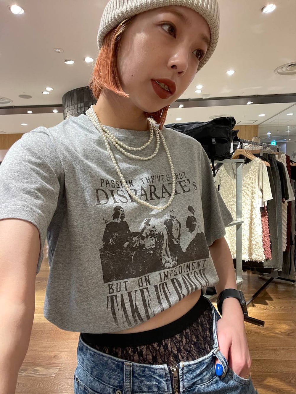 ブルー系のスカート、ブラック系のショルダーバッグ、グレー系のTシャツ/カットソーを着用したレディースの夏コーディネートの2枚目の写真