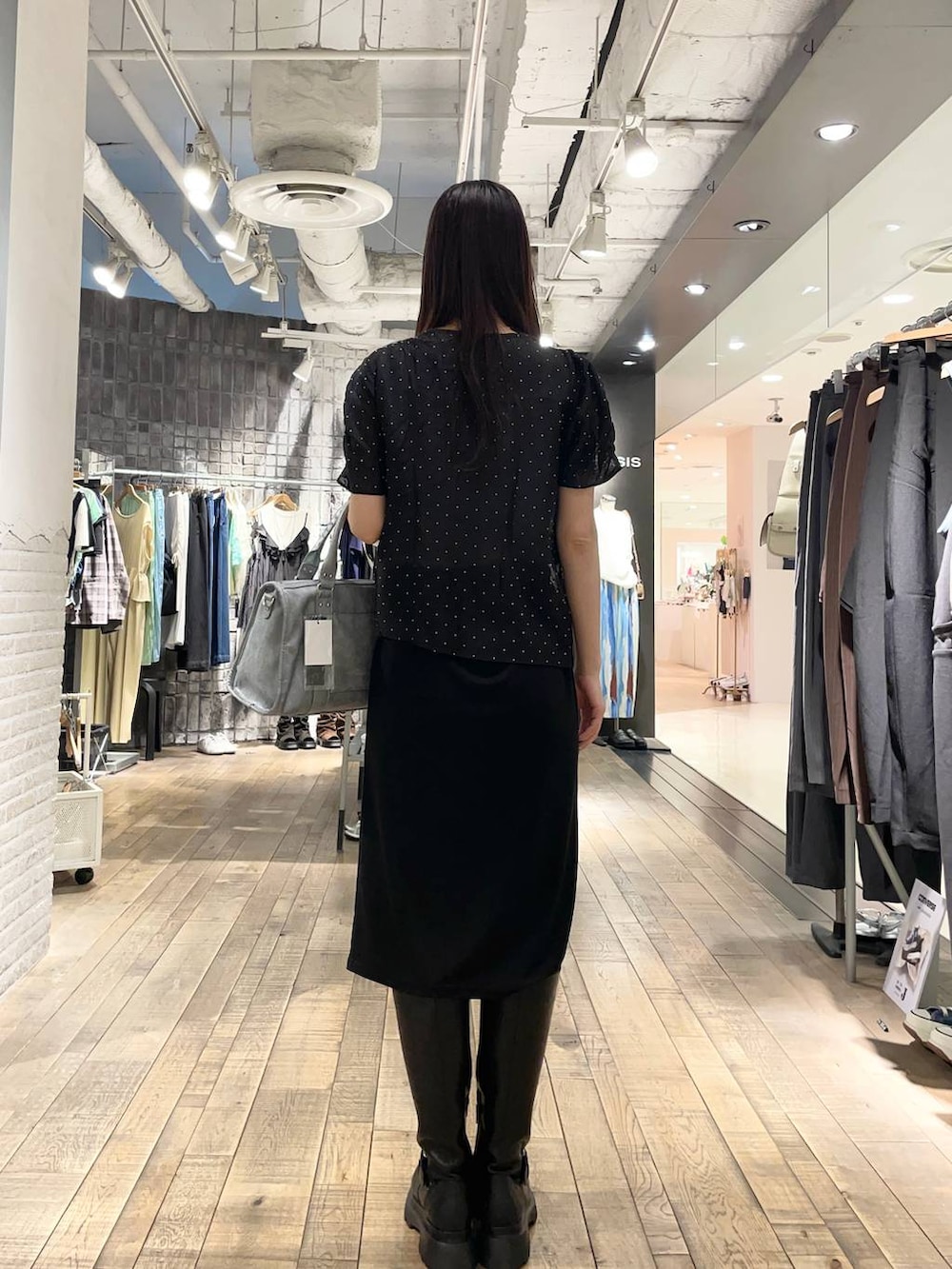 ブラック系のスカート、ブラック系のシャツ/ブラウス、ブルー系のボストンバッグを着用したレディースの夏コーディネートの2枚目の写真