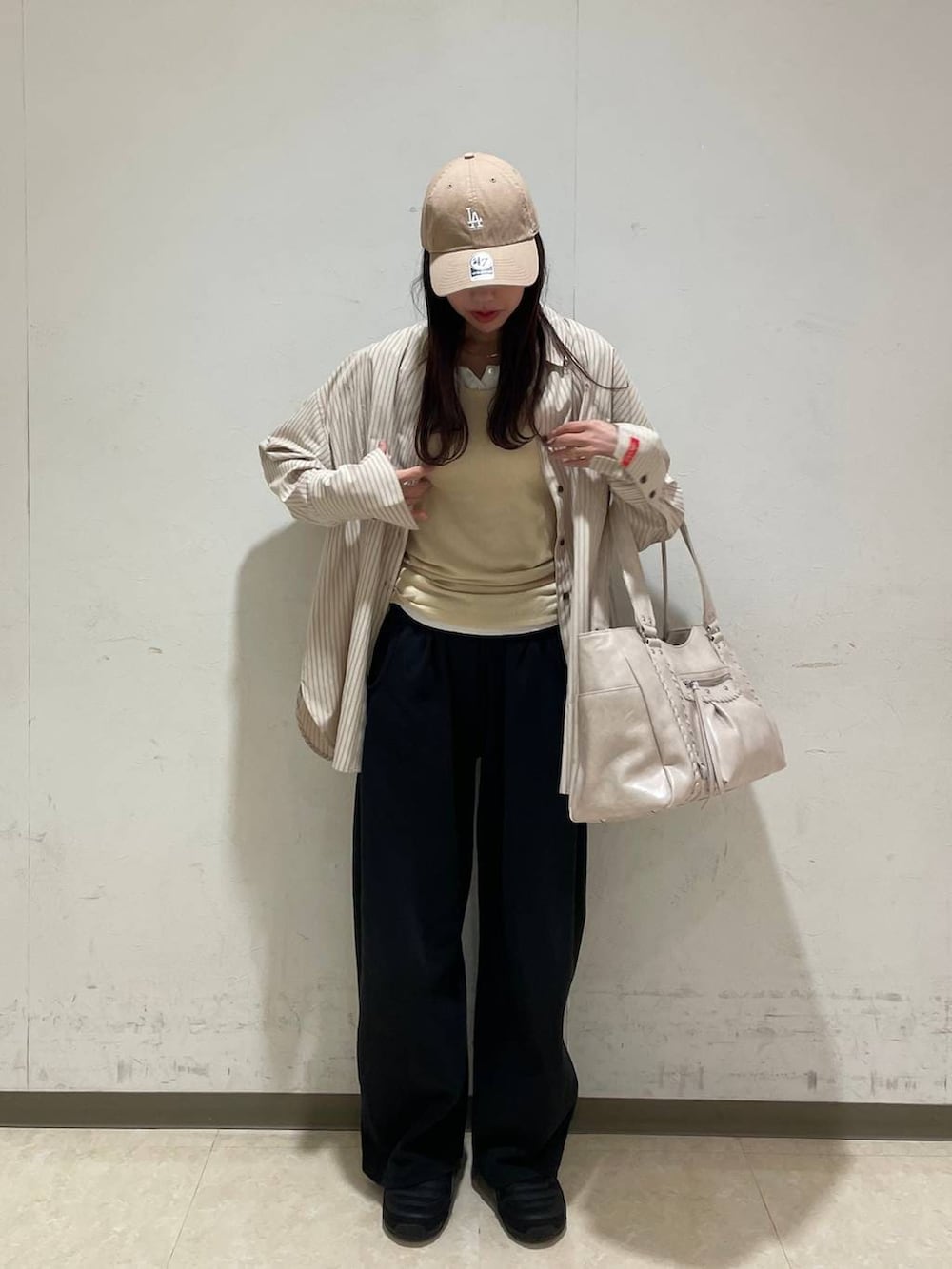 イエロー系のタンクトップ、ホワイト系のTシャツ/カットソー、ホワイト系のトートバッグを着用したレディースの春コーディネートの5枚目の写真