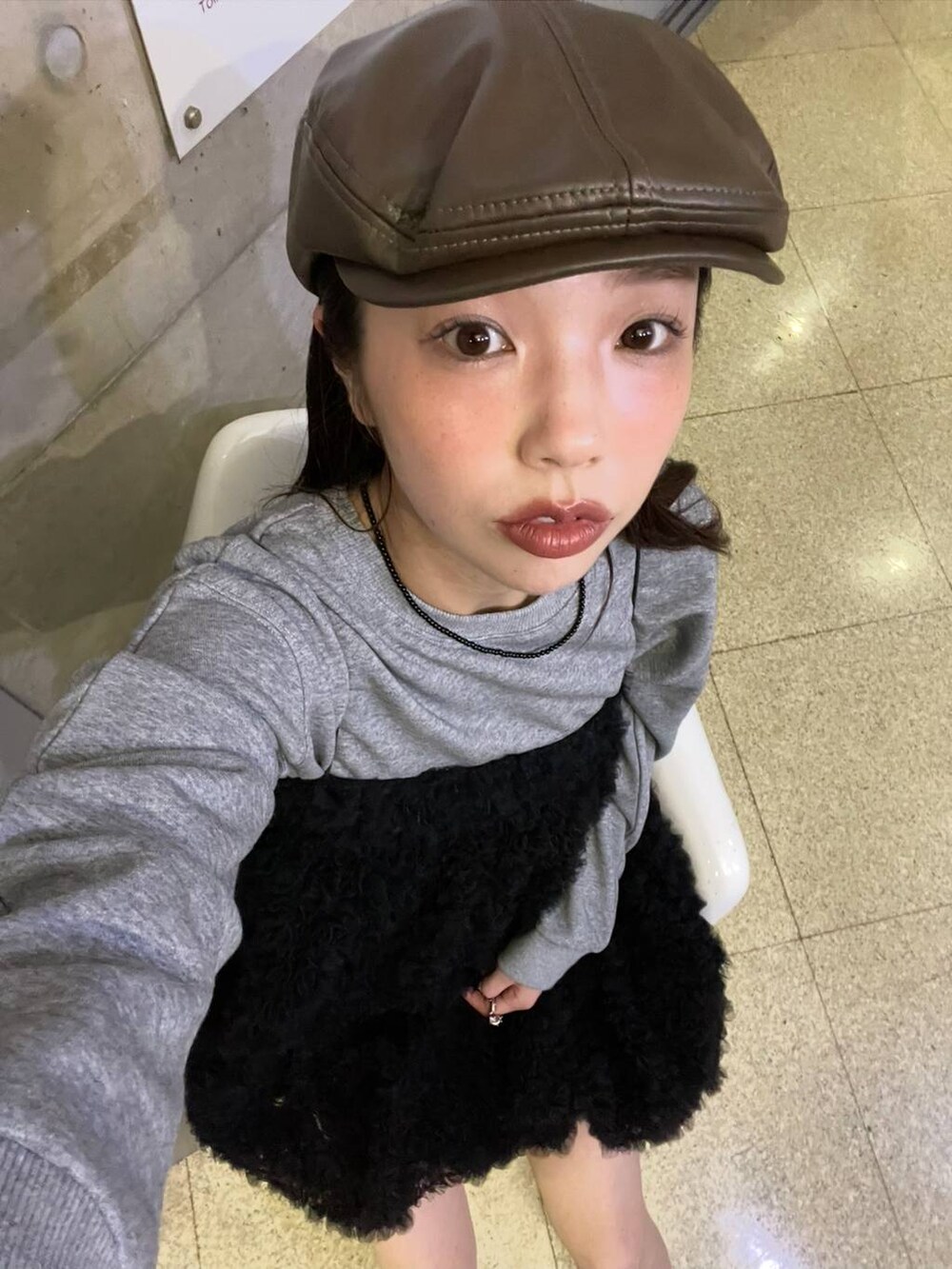 グレー系のスウェット、ブラウン系のハンチング/ベレー帽を着用したレディースの秋コーディネートの3枚目の写真