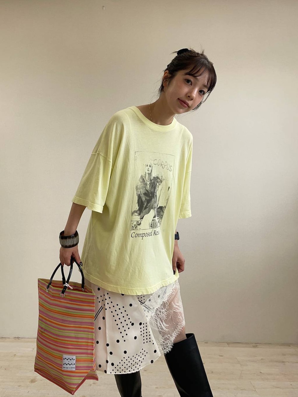 ホワイト系のチュニック、イエロー系のTシャツ/カットソー、ブラック系のブーツを着用したレディースの夏コーディネートの3枚目の写真