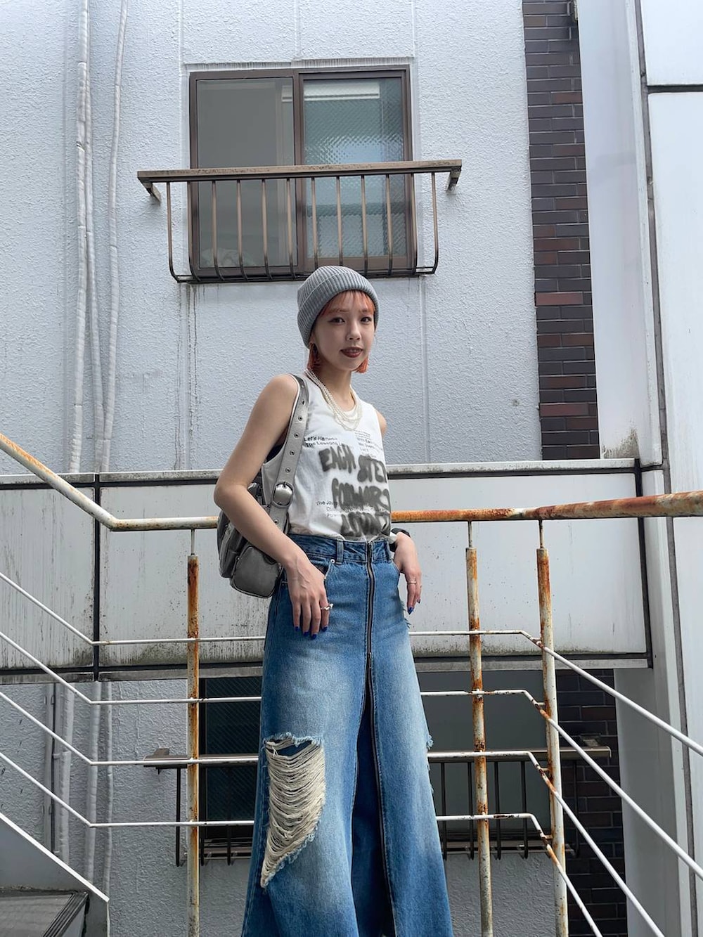 シルバー系のサンダル、ブルー系のスカート、シルバー系のショルダーバッグを着用したレディースの夏コーディネートの3枚目の写真