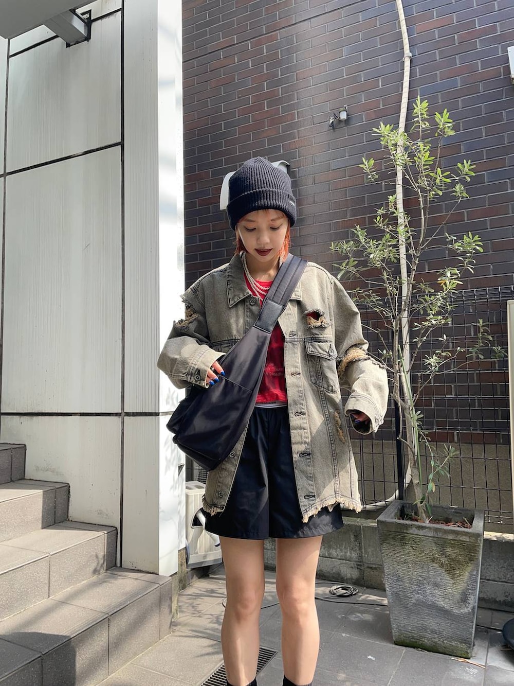 ブラック系のその他パンツ、ブラック系のショルダーバッグ、レッド系のTシャツ/カットソーを着用したレディースの夏コーディネートの4枚目の写真
