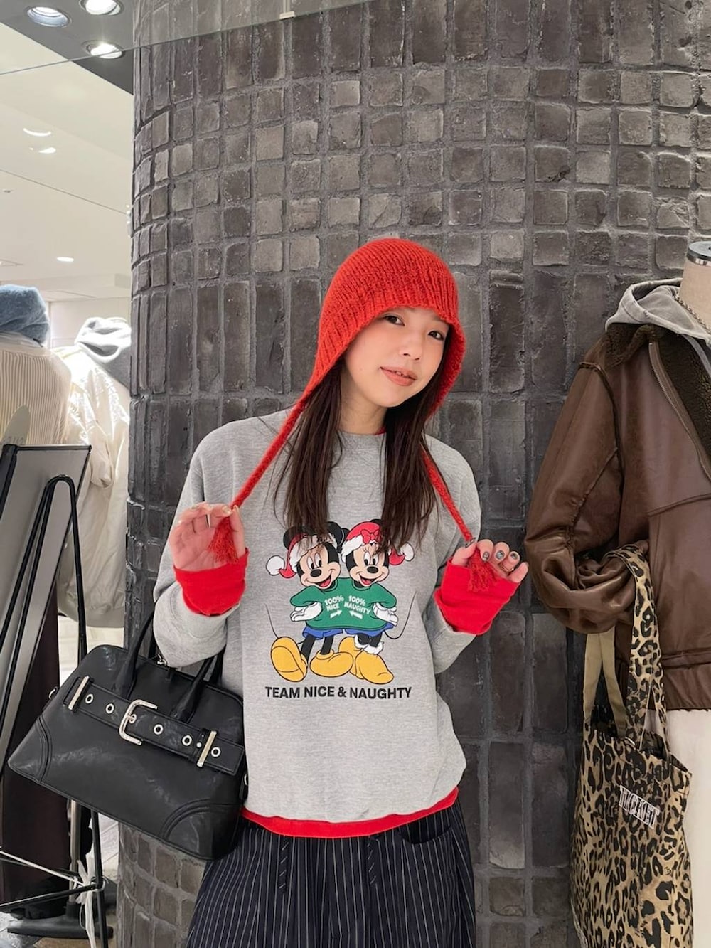 ブラック系のスニーカー、ブルー系のスラックス、レッド系のTシャツ/カットソーを着用したレディースの冬コーディネートの2枚目の写真