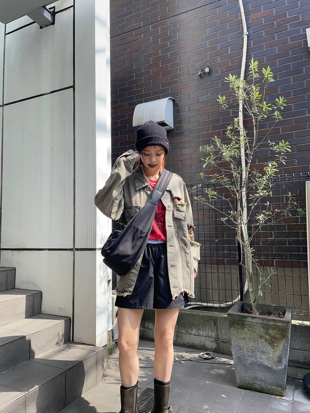 ブラック系のその他パンツ、ブラック系のショルダーバッグ、レッド系のTシャツ/カットソーを着用したレディースの夏コーディネートの2枚目の写真