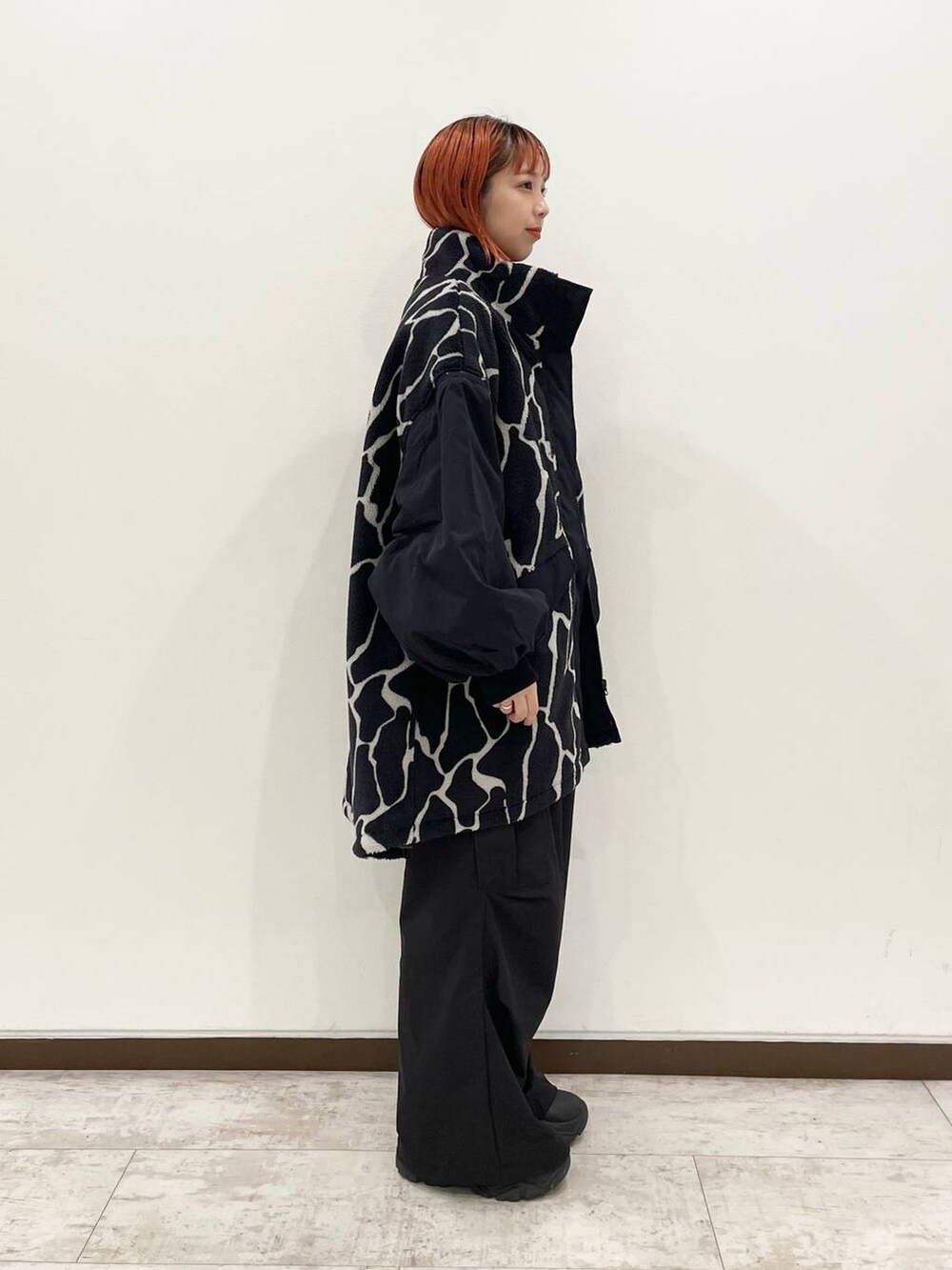 ブラック系のブルゾン、ブラック系のブーツ、ブラック系のカーゴパンツを着用したレディースの秋コーディネートの2枚目の写真