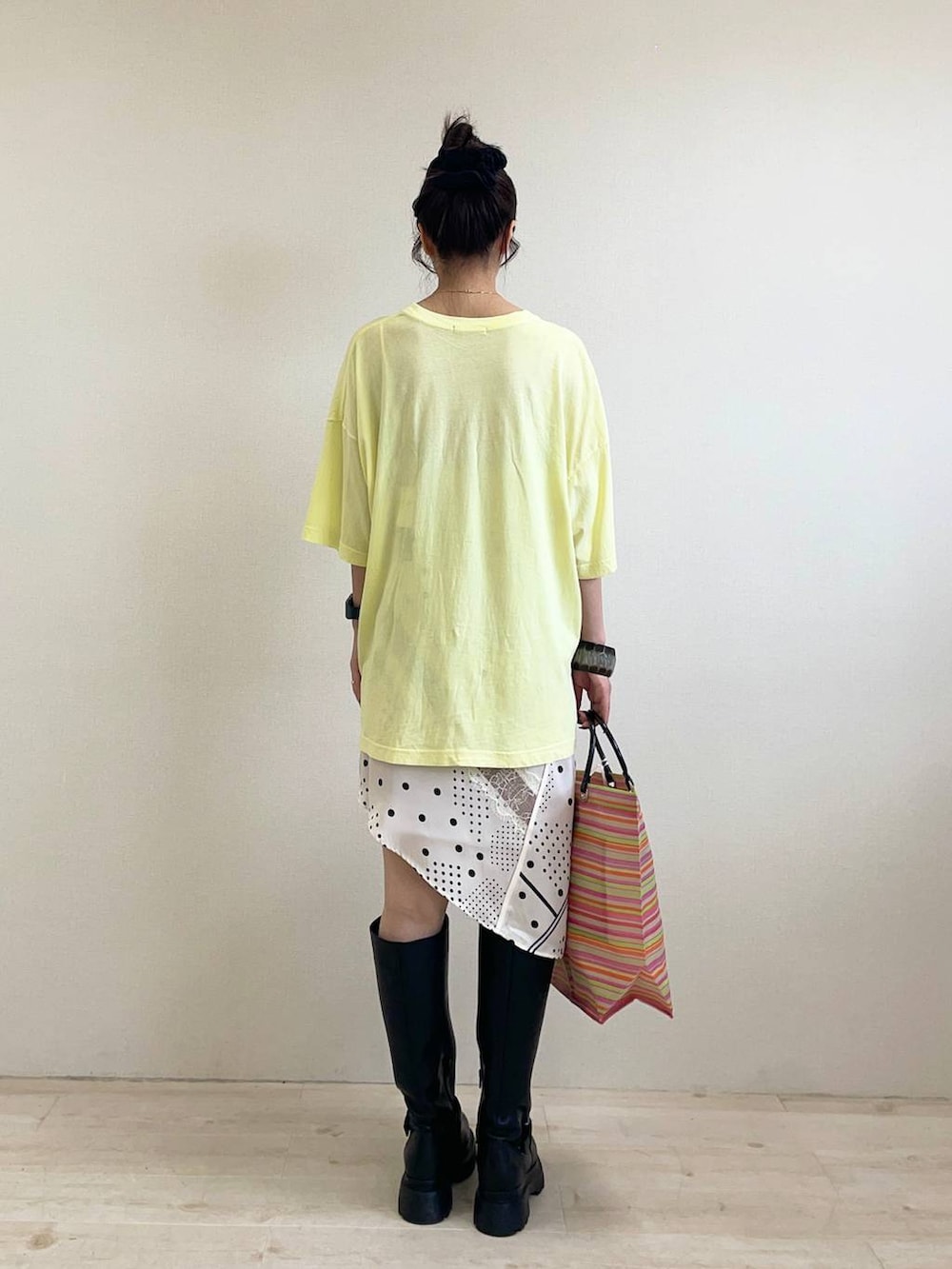 ホワイト系のチュニック、イエロー系のTシャツ/カットソー、ブラック系のブーツを着用したレディースの夏コーディネートの2枚目の写真