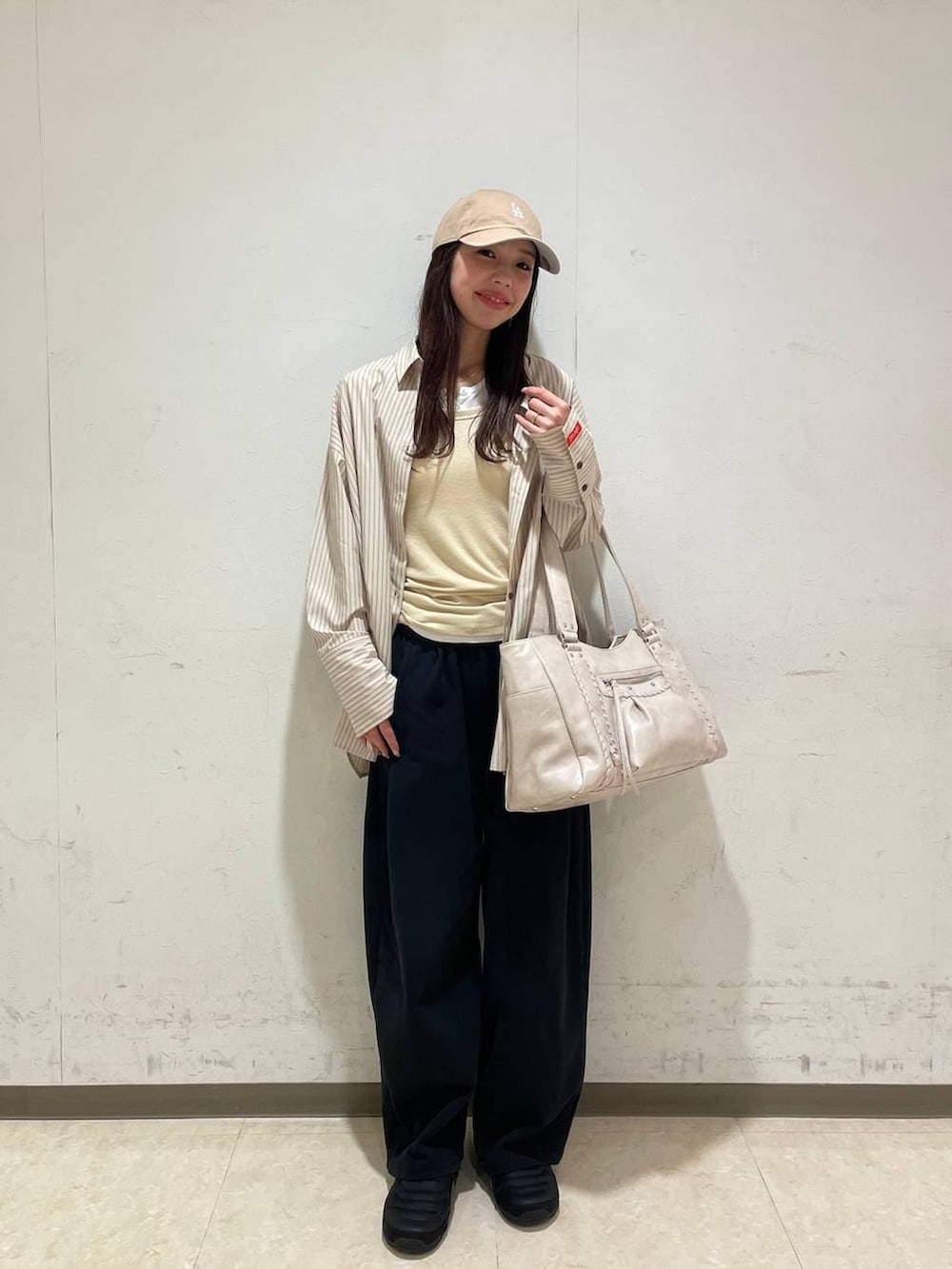 イエロー系のタンクトップ、ホワイト系のTシャツ/カットソー、ホワイト系のトートバッグを着用したレディースの春コーディネートの7枚目の写真