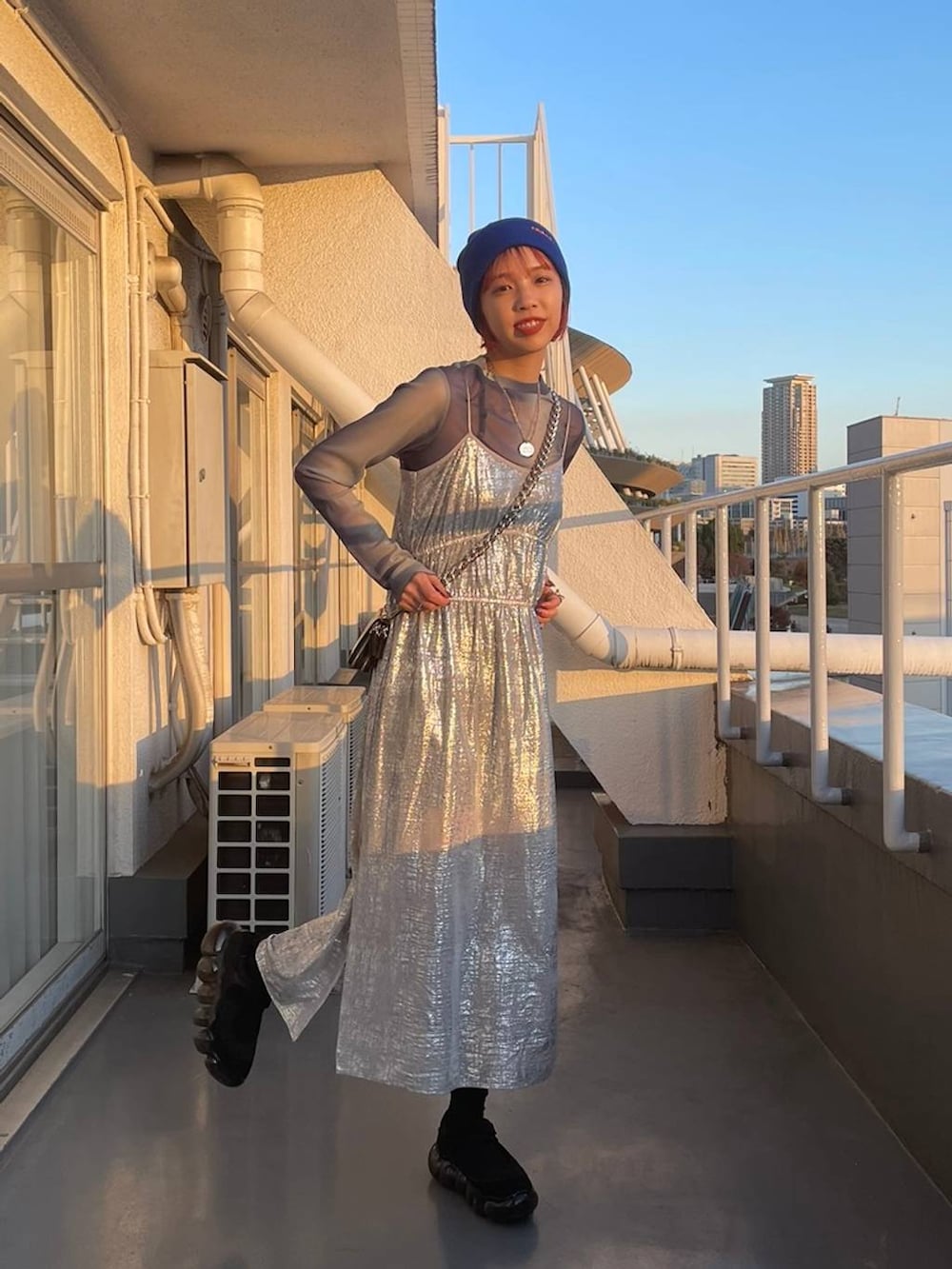 ブラック系のショルダーバッグ、ブルー系のTシャツ/カットソー、シルバー系のワンピースを着用したレディースの冬コーディネートの2枚目の写真