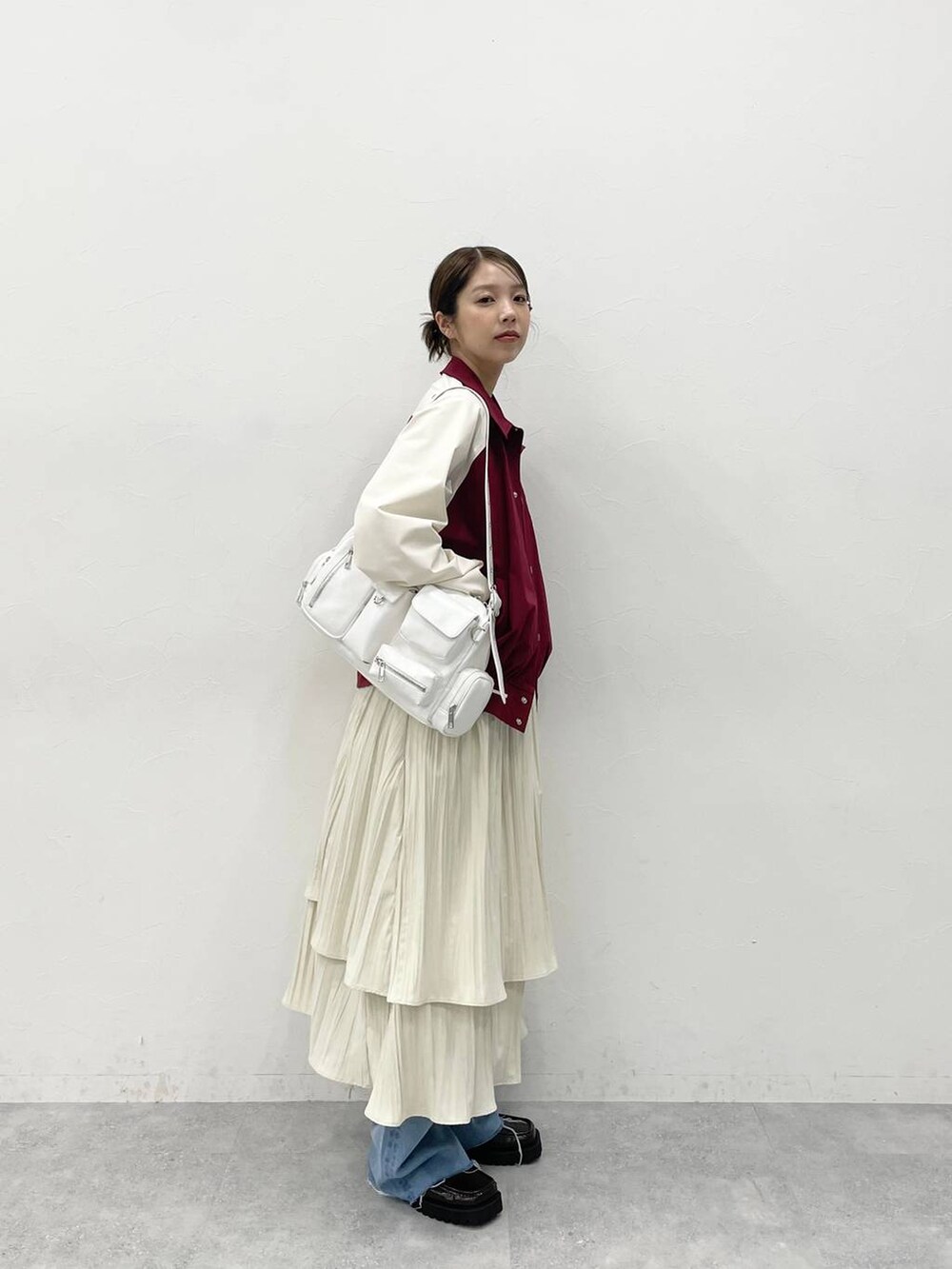 ホワイト系のショルダーバッグ、ブラウン系のローファー、ホワイト系のワンピースを着用したレディースの冬コーディネートの2枚目の写真