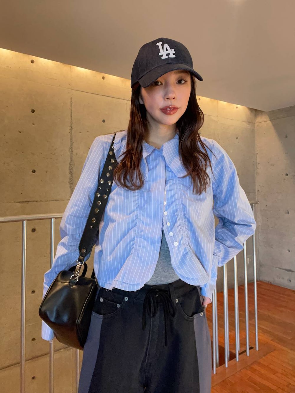 ブラック系のボストンバッグ、グレー系のTシャツ/カットソー、ブラック系のドレスシューズを着用したレディースの冬コーディネートの2枚目の写真