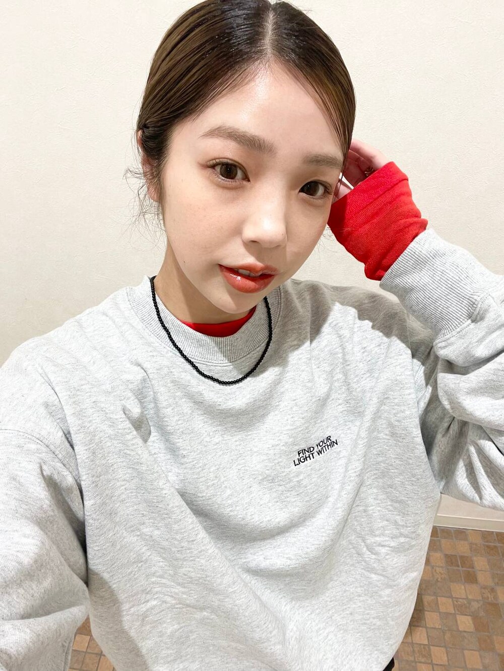 レッド系のTシャツ/カットソー、ブラック系のブーツ、ブラック系のスカートを着用したレディースの冬コーディネートの3枚目の写真