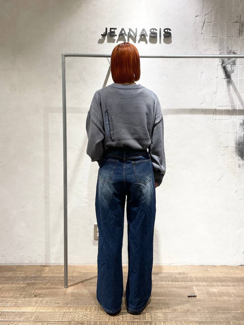 ブラック系のブーツ、ブルー系のデニムパンツ、グレー系のニット/セーターを着用したレディースの秋コーディネートの3枚目の写真