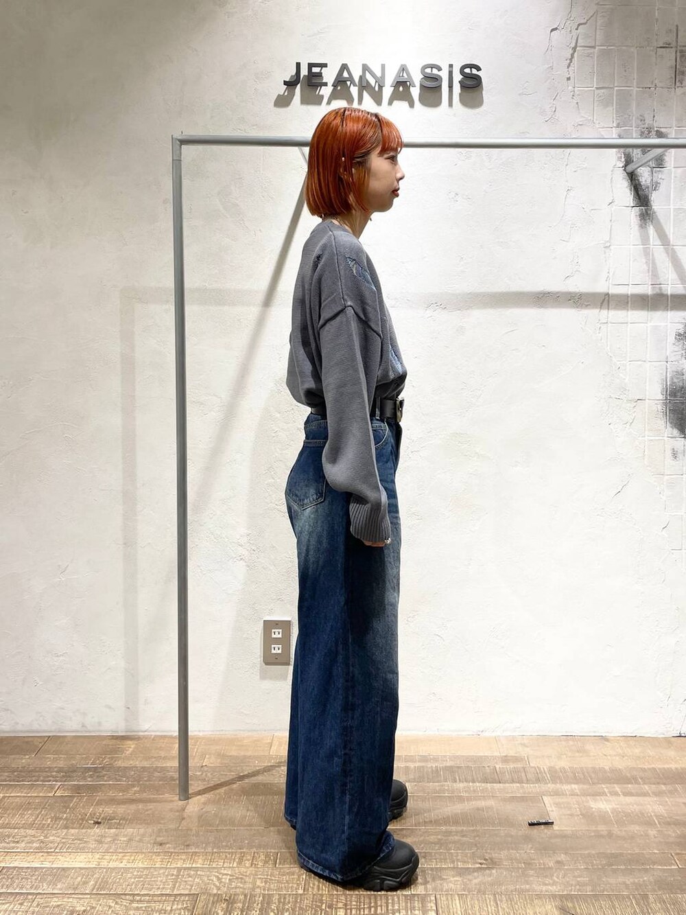 ブラック系のブーツ、ブルー系のデニムパンツ、グレー系のニット/セーターを着用したレディースの秋コーディネートの2枚目の写真