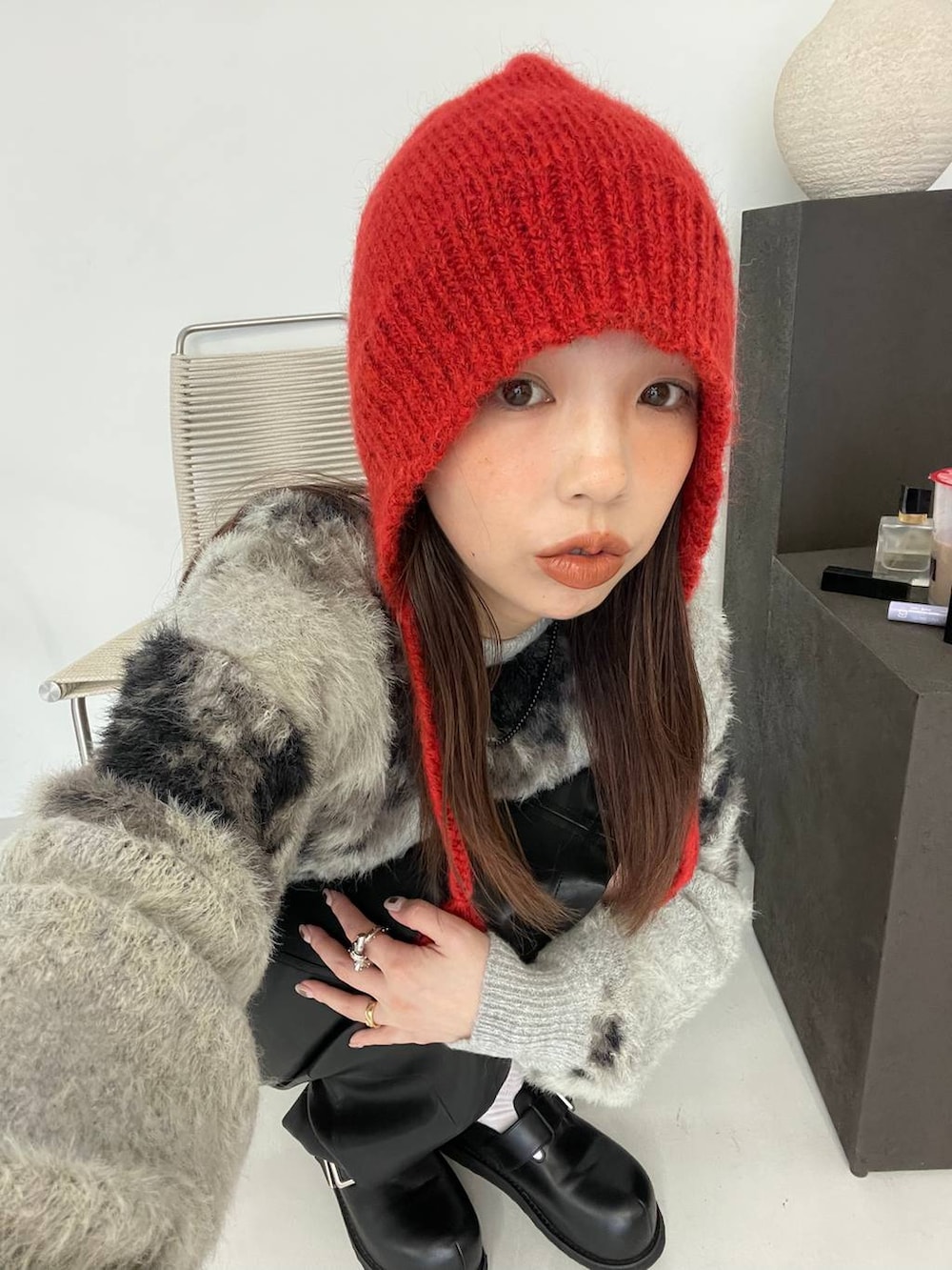 グレー系のニット/セーター、ブラック系のボストンバッグ、ブラック系のその他シューズを着用したレディースの秋コーディネートの4枚目の写真