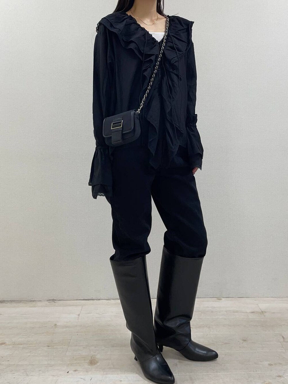 ブラック系のブーツ、ブラック系のデニムパンツ、ブラック系のシャツ/ブラウスを着用したレディースの秋コーディネートの2枚目の写真