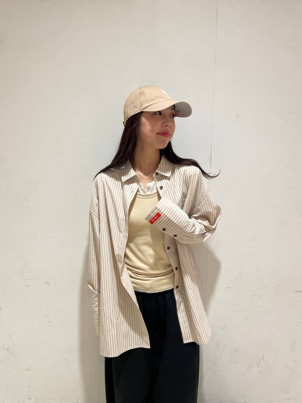 イエロー系のタンクトップ、ホワイト系のTシャツ/カットソー、ホワイト系のトートバッグを着用したレディースの春コーディネートの4枚目の写真