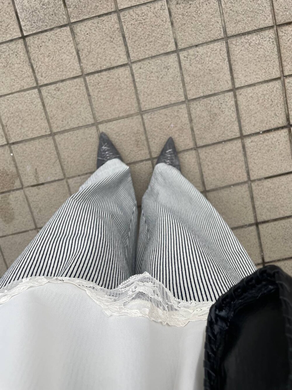 ホワイト系のキャミソール、グレー系のタンクトップ、ブラック系のパンプスを着用したレディースの夏コーディネートの5枚目の写真