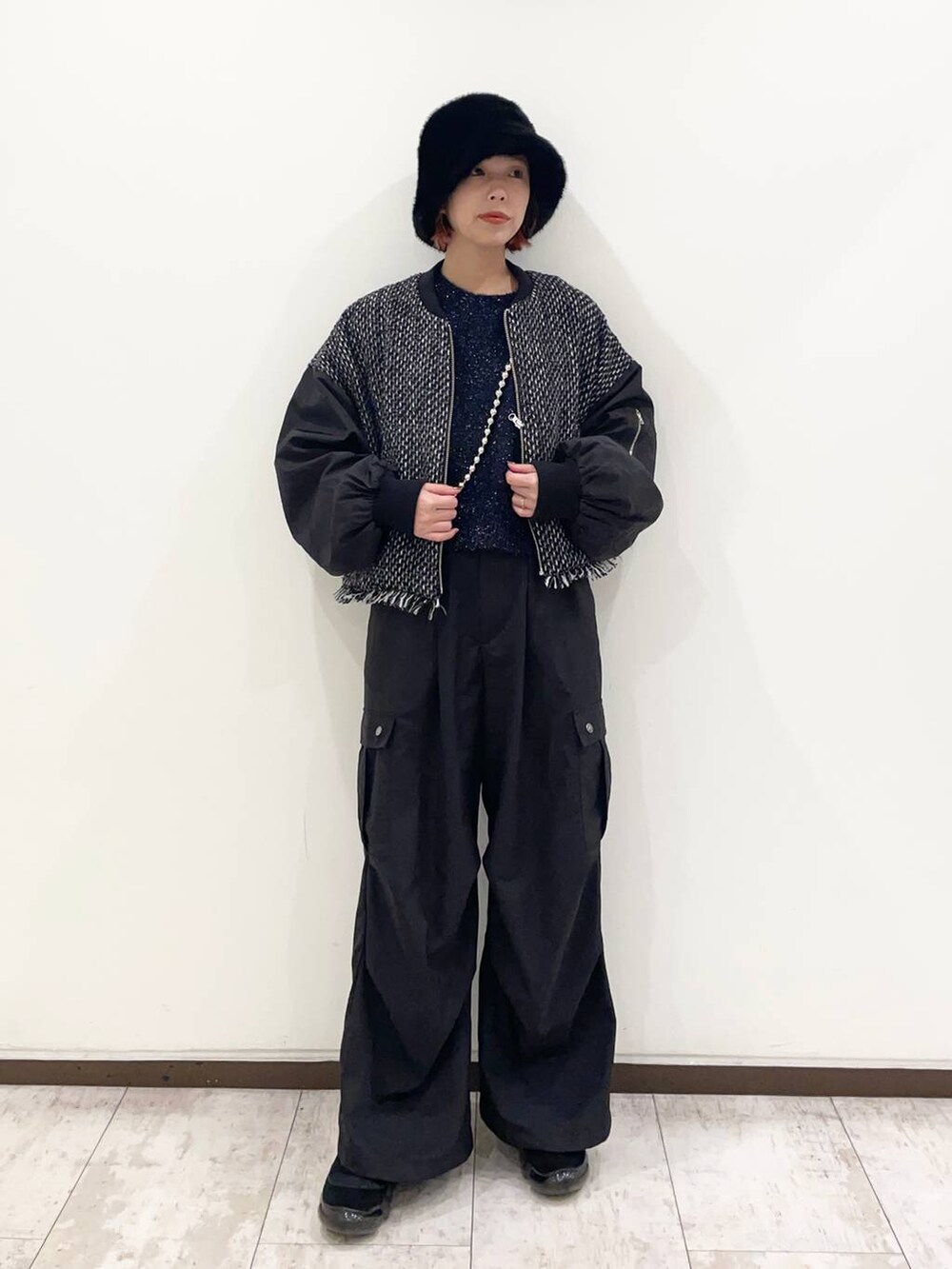 ブルー系のニット/セーター、ブラック系のカーゴパンツ、シルバー系のスマホグッズを着用したレディースの冬コーディネートの3枚目の写真