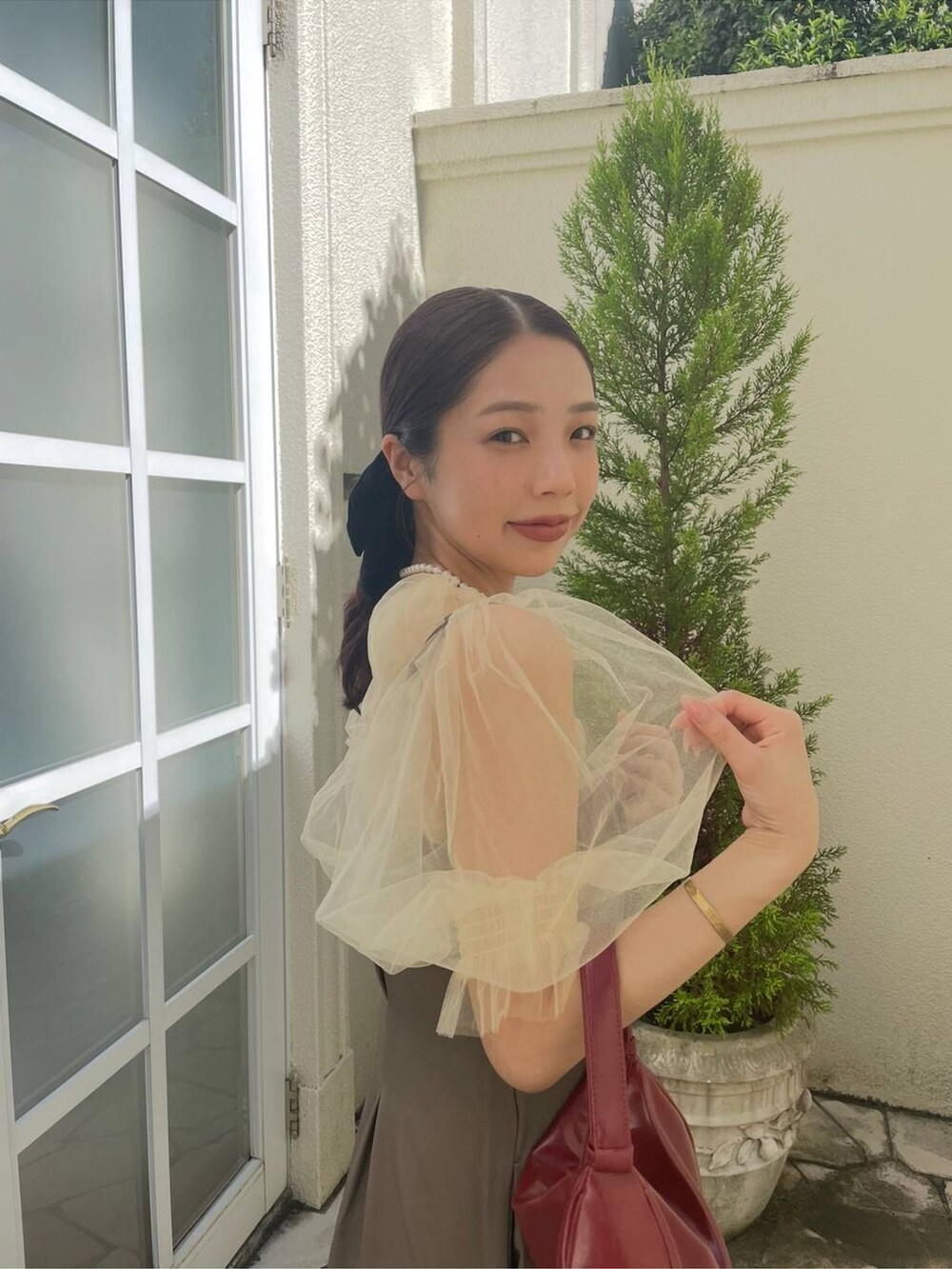 イエロー系のシャツ/ブラウスを着用したレディースの夏コーディネートの2枚目の写真