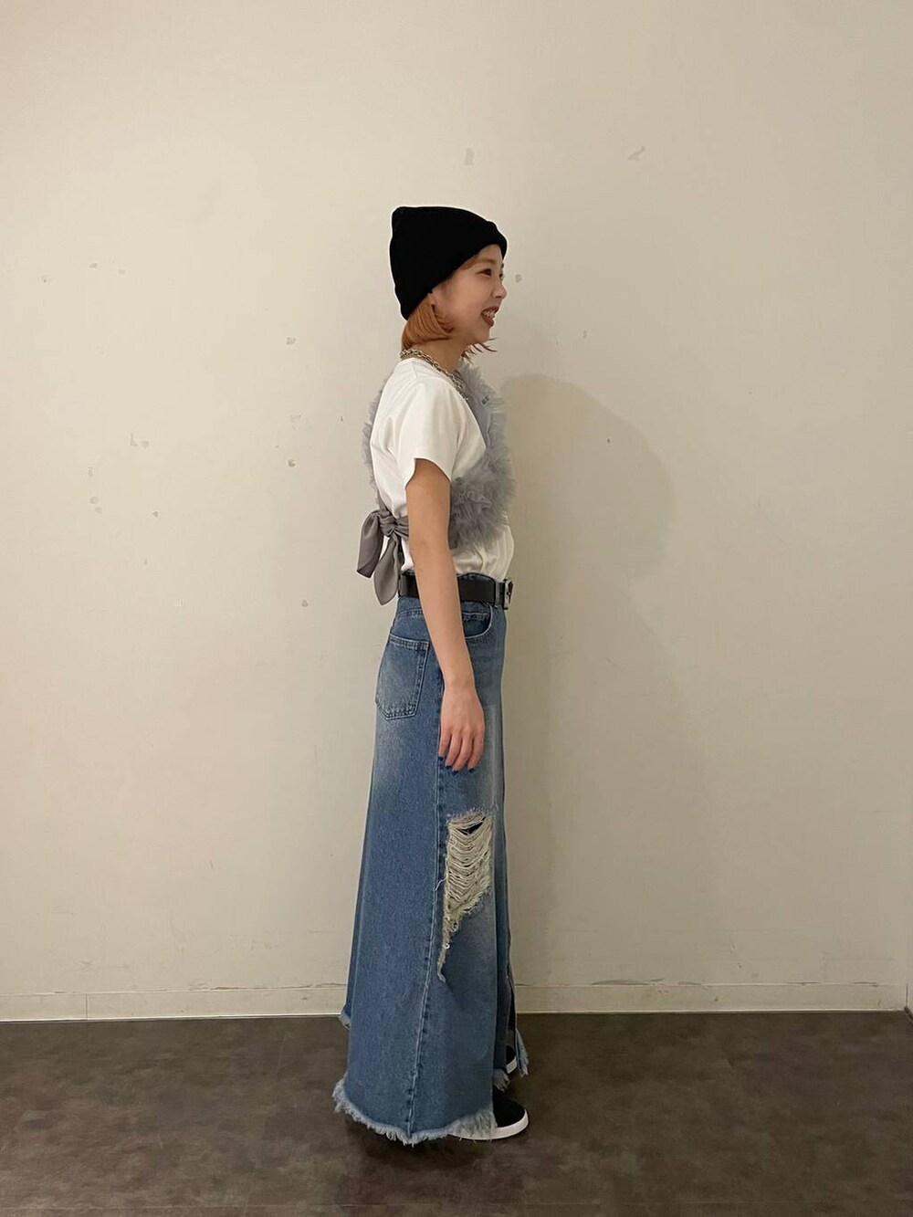 ブルー系のスカート、グレー系のTシャツ/カットソー、シルバー系のネックレスを着用したレディースの夏コーディネートの2枚目の写真