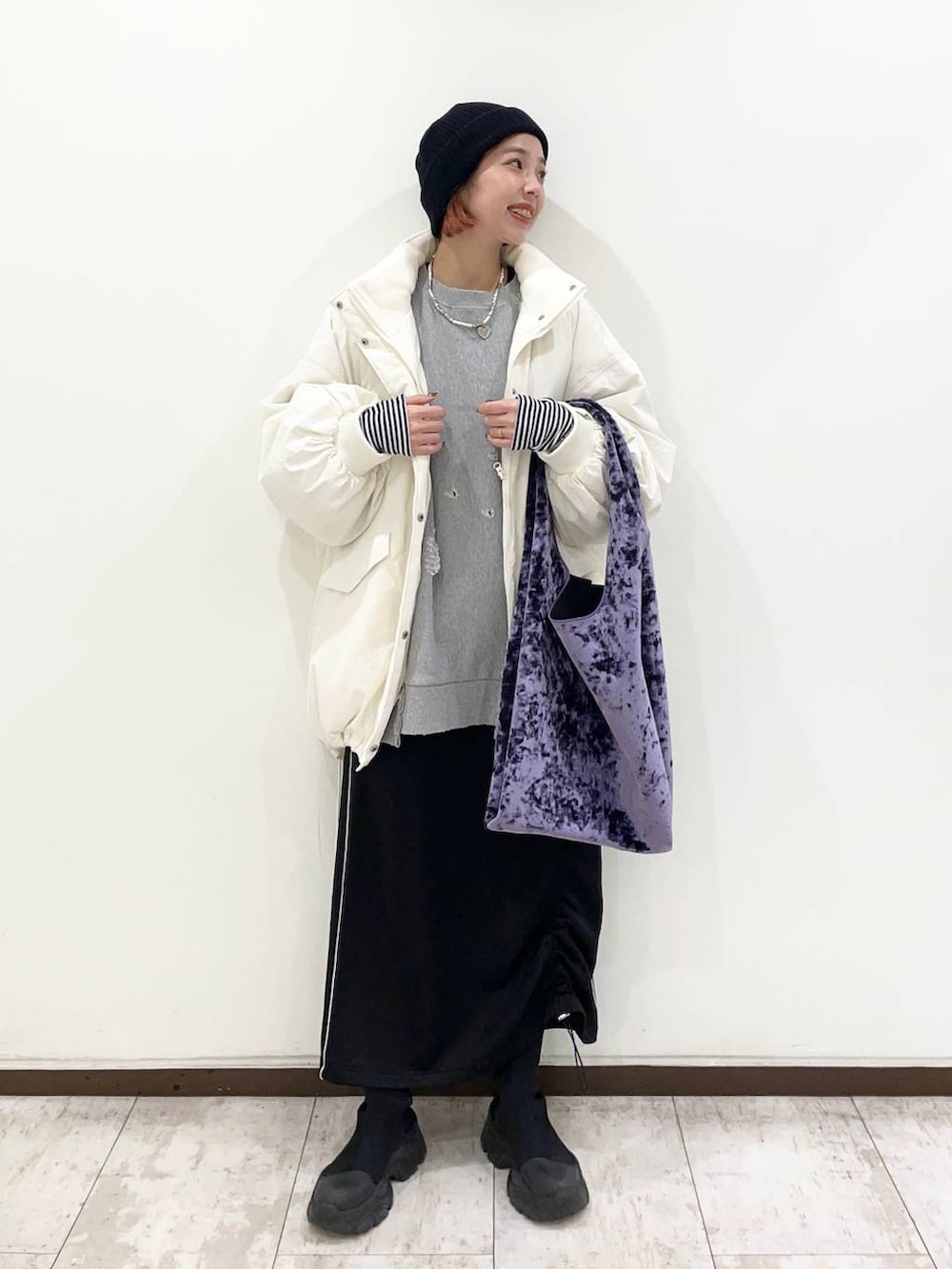 パープル系のトートバッグ、ブラック系のブーツ、グレー系のスウェットを着用したレディースの冬コーディネートの3枚目の写真