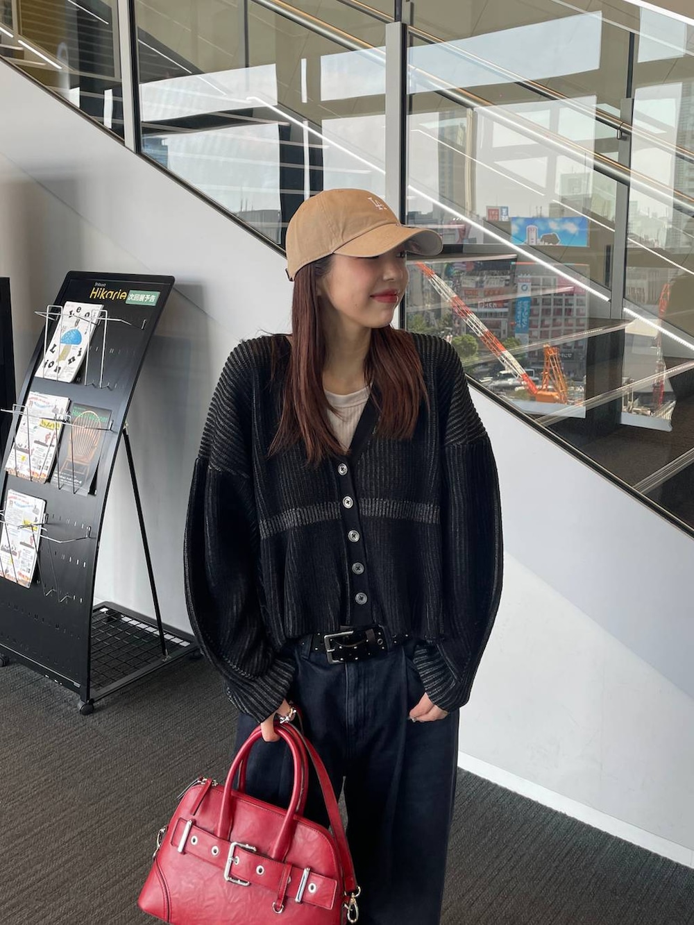 ベージュ系のタンクトップ、ブラック系のブーツ、ブラック系のデニムパンツを着用したレディースの秋コーディネートの3枚目の写真