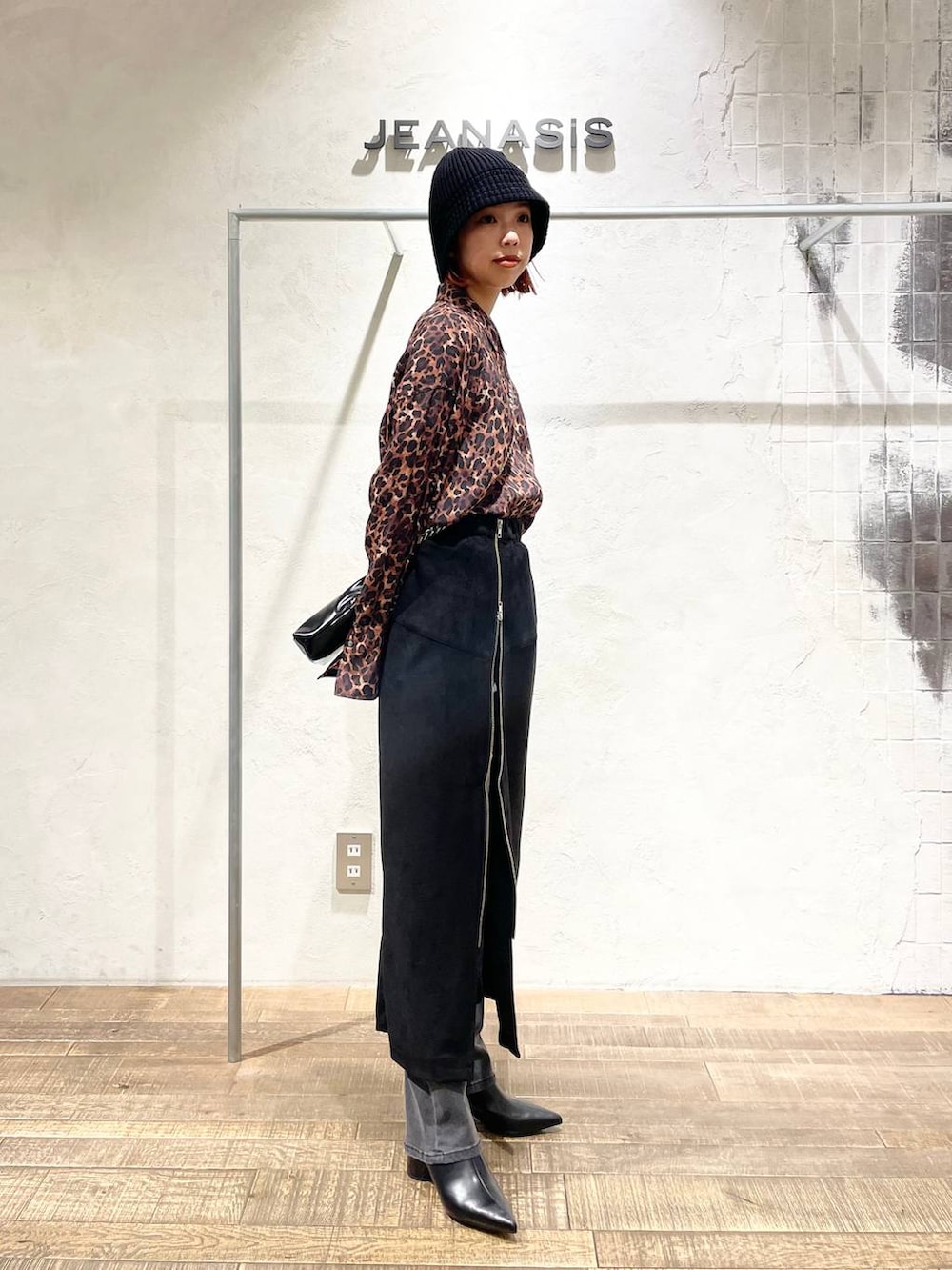 ブラック系のスカート、ブラック系のブーツ、ブラウン系のシャツ/ブラウスを着用したレディースの秋コーディネートの2枚目の写真