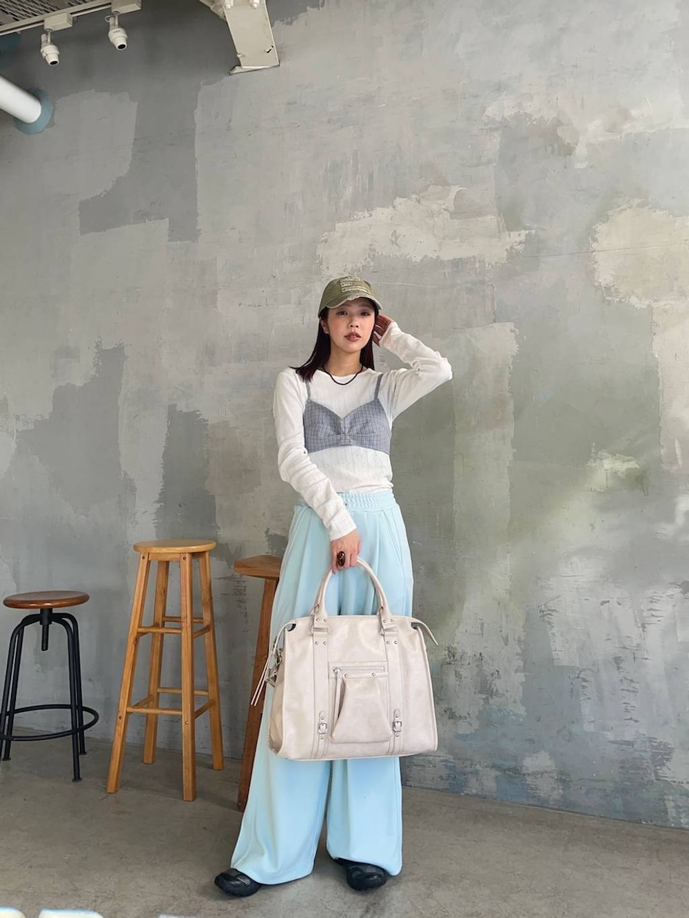 ブラック系のスニーカー、ホワイト系のトートバッグ、ホワイト系のTシャツ/カットソーを着用したレディースの冬コーディネートの2枚目の写真