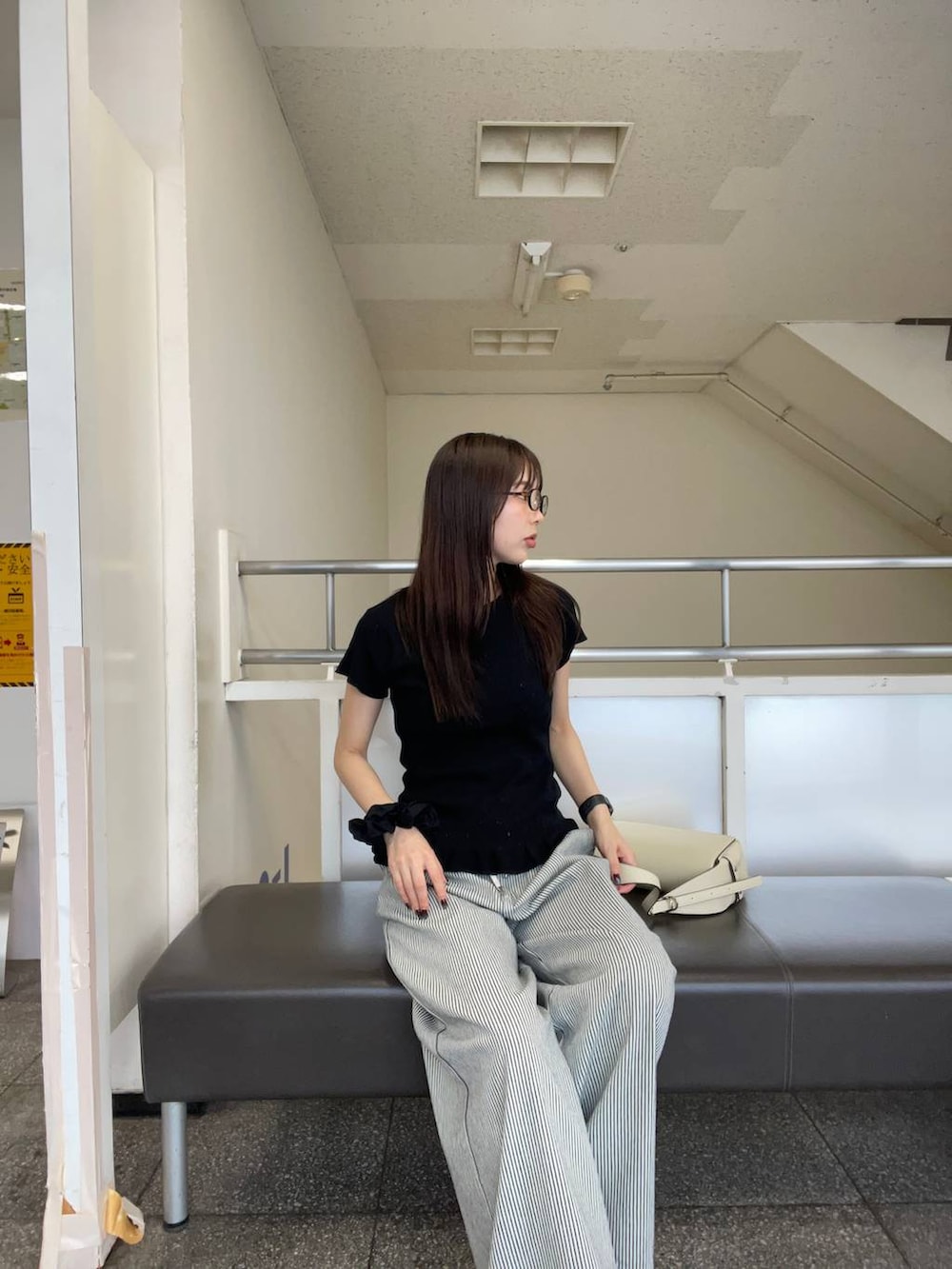 ブラック系のパンプス、ホワイト系のショルダーバッグ、ホワイト系のデニムパンツを着用したレディースの夏コーディネートの4枚目の写真