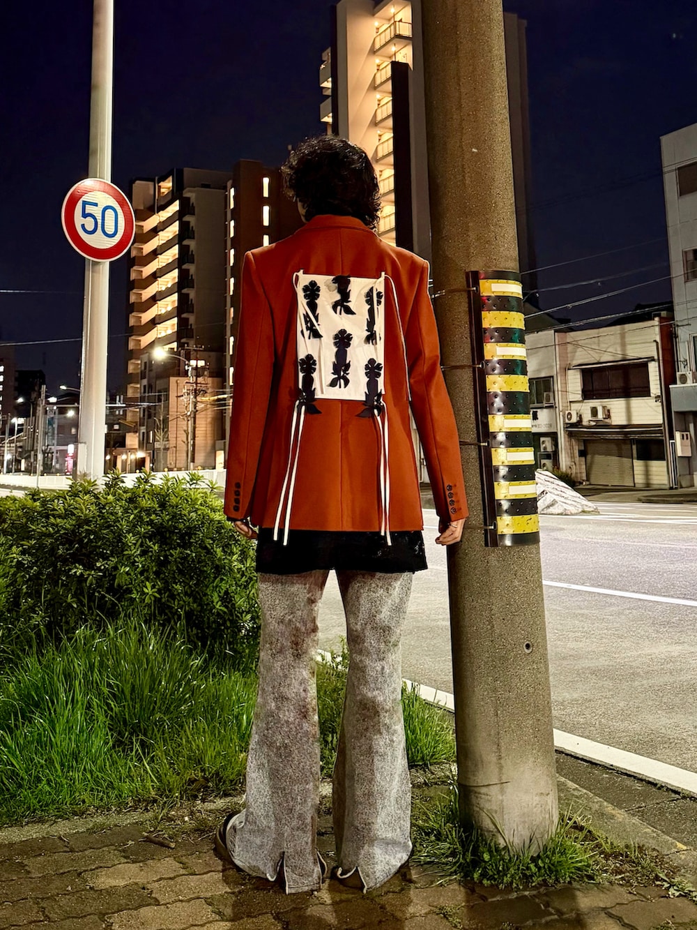 オレンジ系のその他アウター、ブラック系のデニムパンツ、ブラック系のTシャツ/カットソーを着用したメンズの春コーディネートの3枚目の写真