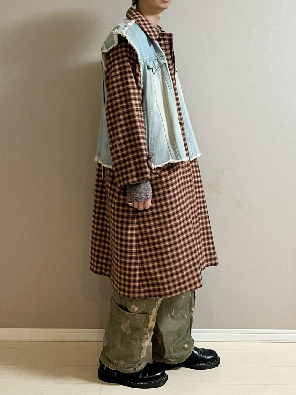 オレンジ系のステンカラーコート、ブルー系のデニムジャケット、ブラック系のショルダーバッグを着用したメンズの冬コーディネートの2枚目の写真