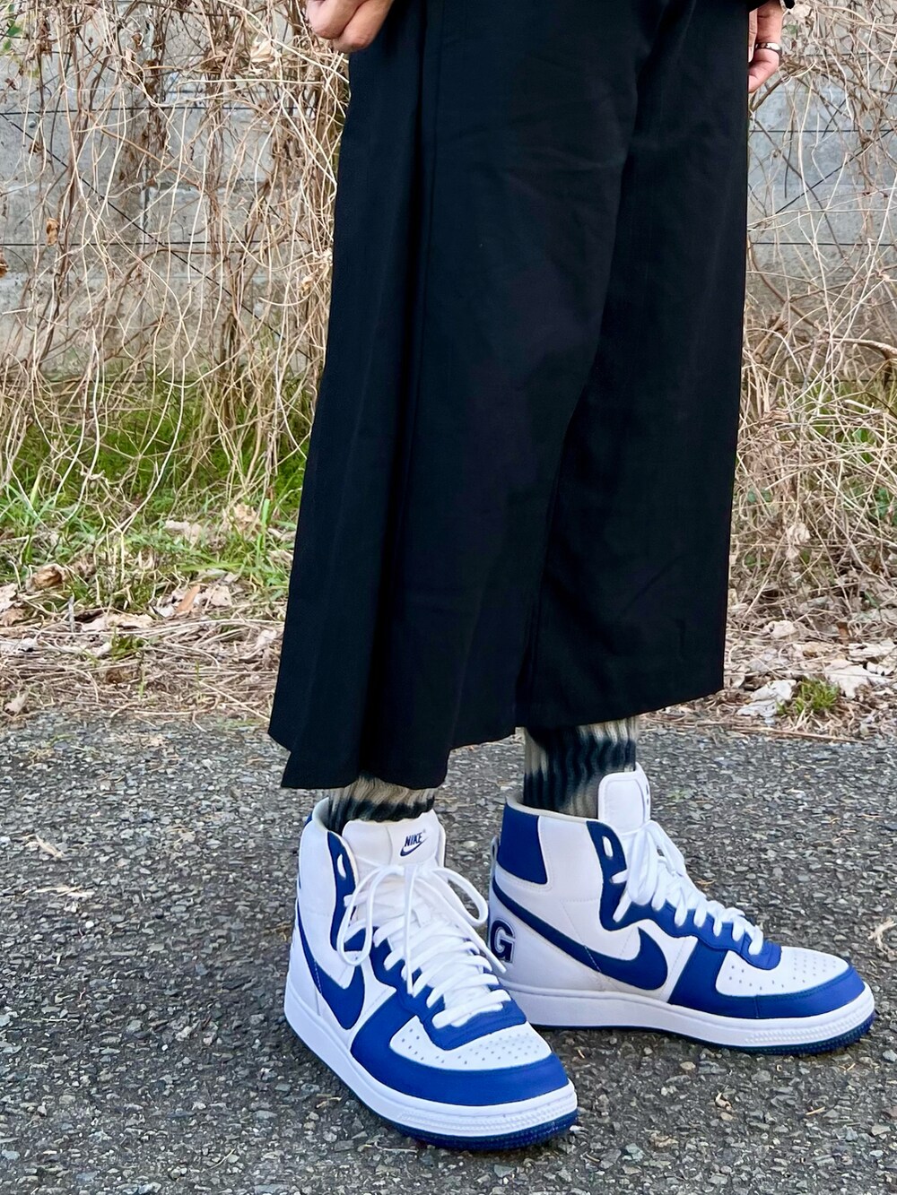 ブラック系のパンツ、ブルー系のスニーカー、ブラック系のTシャツ/カットソーを着用したメンズの春コーディネートの5枚目の写真