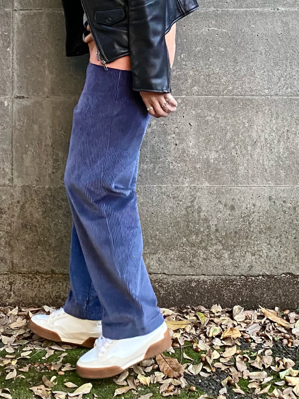 ブラック系のライダースジャケット、ブルー系のパンツ、ホワイト系のスニーカーを着用したメンズの秋コーディネートの3枚目の写真