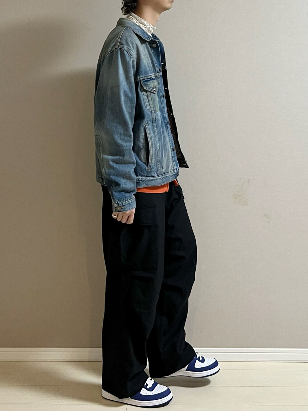 ブラック系のカーゴパンツ、ブルー系のスニーカー、オレンジ系のカーディガン/ボレロを着用したメンズの冬コーディネートの2枚目の写真