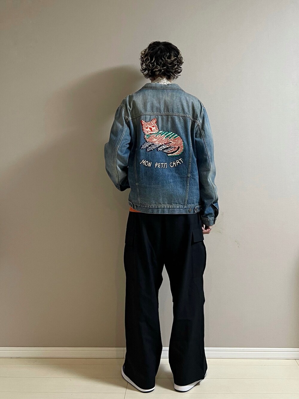 ブラック系のカーゴパンツ、ブルー系のスニーカー、オレンジ系のカーディガン/ボレロを着用したメンズの冬コーディネートの3枚目の写真