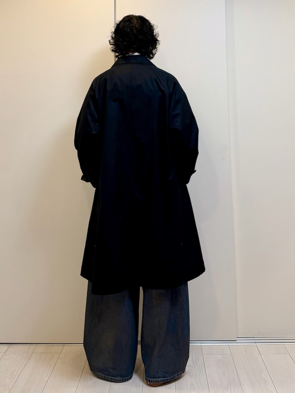 ブラック系のその他アウター、ブラック系のカーディガン/ボレロ、ブラウン系のデニムパンツを着用したメンズの冬コーディネートの3枚目の写真