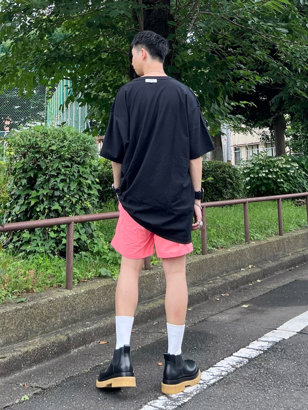 ブラック系のTシャツ/カットソー、ピンク系のパンツ、ブラック系のブーツを着用したメンズの夏コーディネートの2枚目の写真