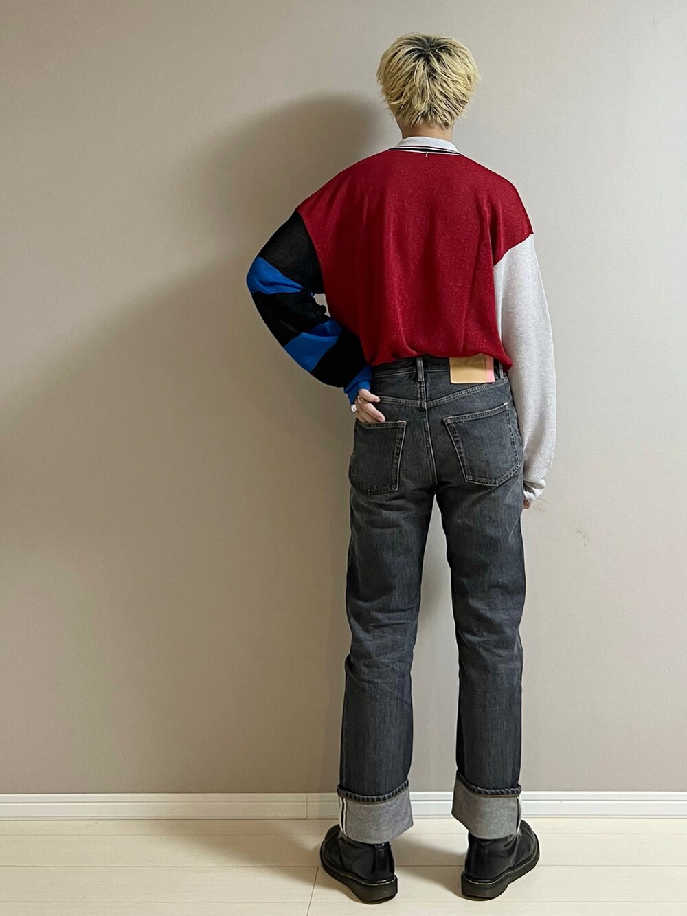 ブラック系のデニムパンツ、ブラック系のブーツ、レッド系のシャツ/ブラウスを着用したメンズの秋コーディネートの3枚目の写真