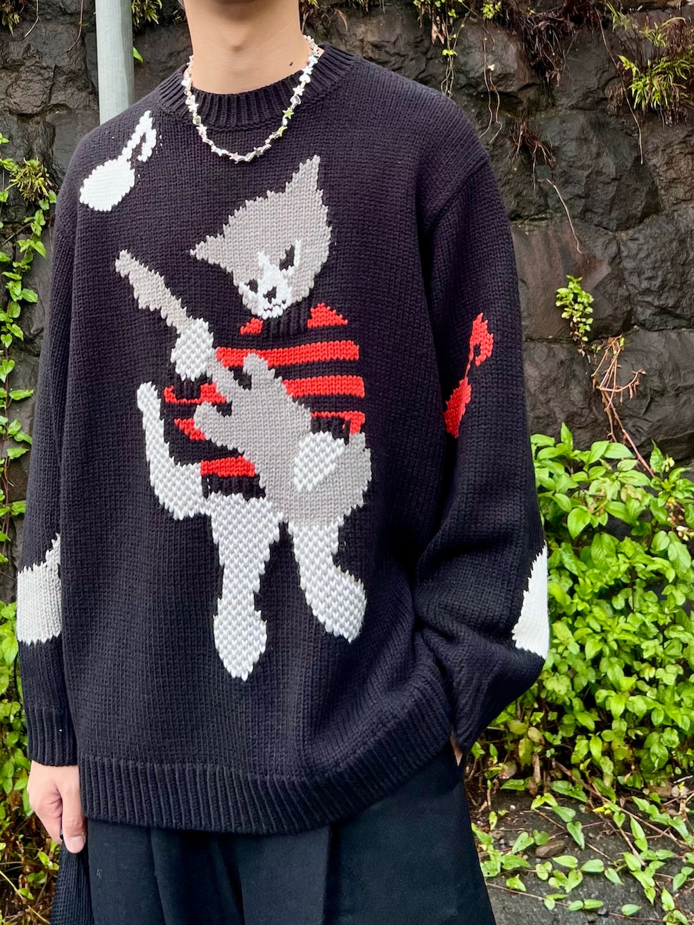 ブラック系のスラックス、ブラック系のブーツ、ブラック系のハンドバッグを着用したメンズの秋コーディネートの3枚目の写真