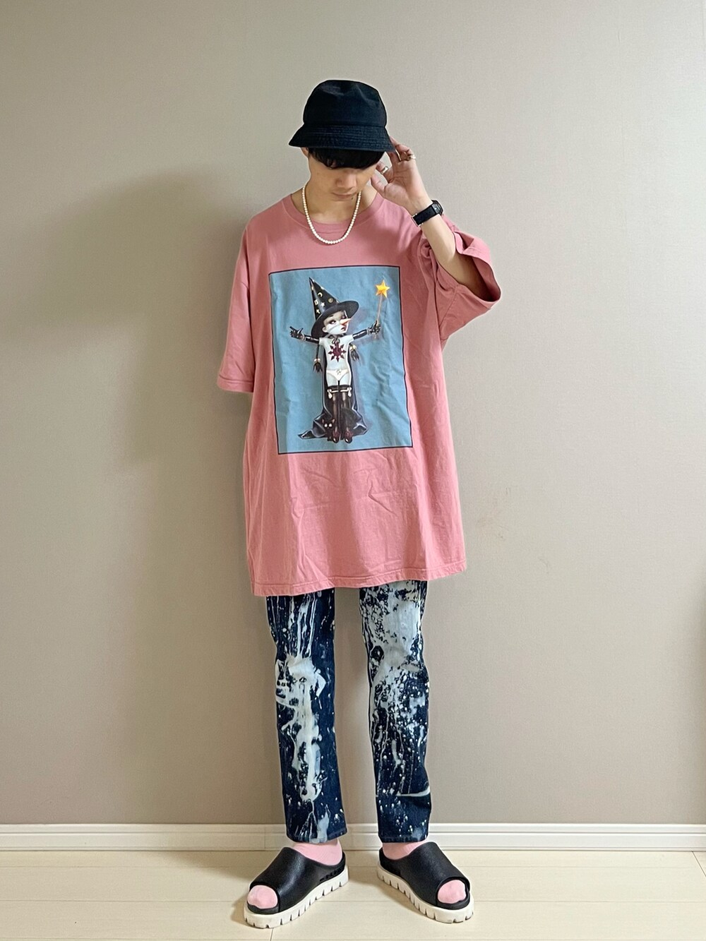 ブラック系のサンダル、ピンク系のTシャツ/カットソー、ブラック系のキャップを着用したメンズの夏コーディネートの2枚目の写真